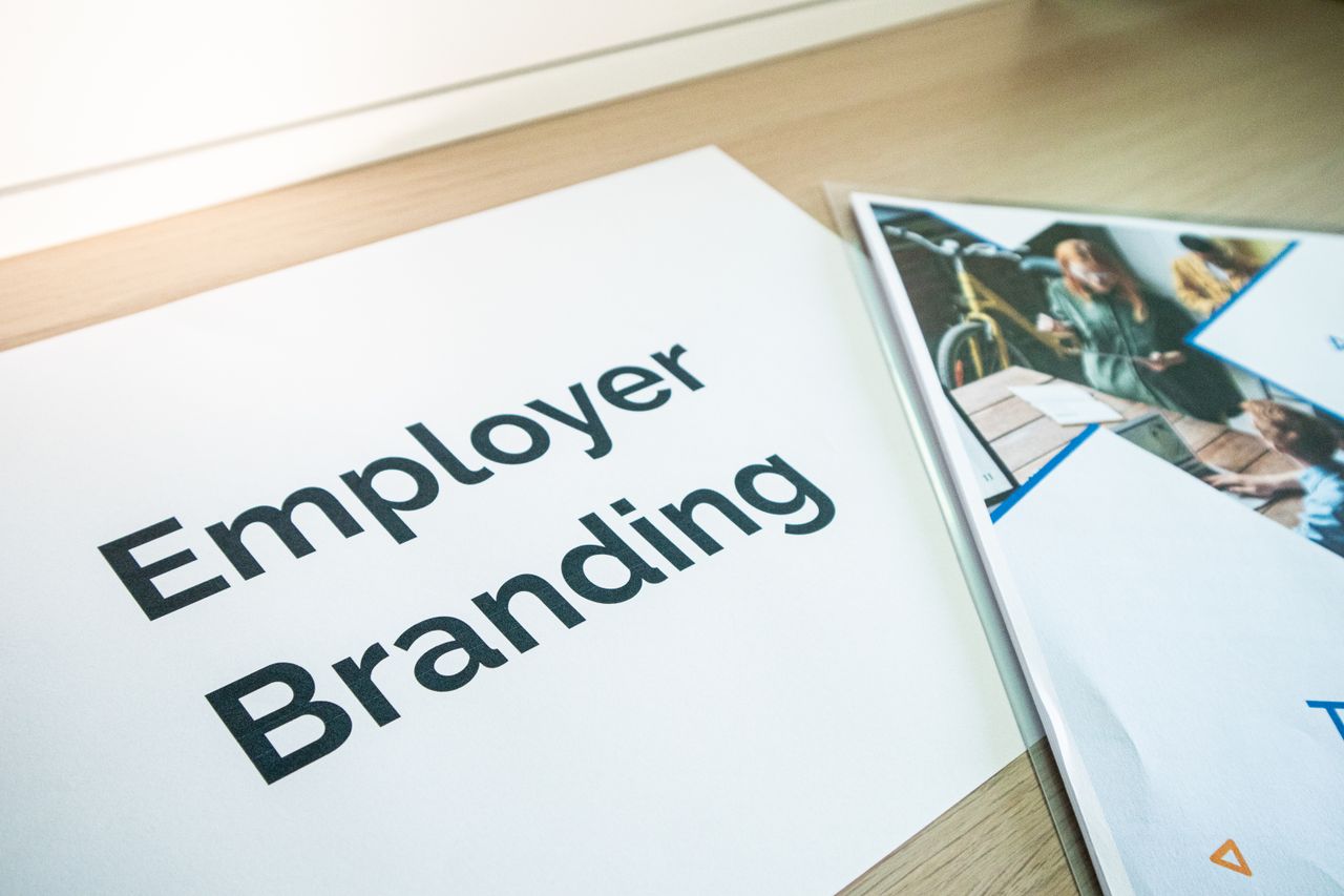 heros-img Mettre l’employer branding à l’honneur avec des documents posés sur un bureau en bois, parfait pour illustrer des concepts d’entreprise.